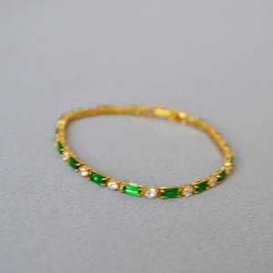 Elegant gold plated bracelet with alternating green emerald-cut and white round stones