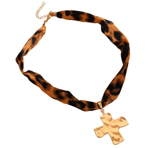 Detail der Choker-Halskette mit Leopardenmuster und gehämmertem goldenem Kreuzanhänger