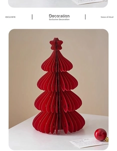 Detail of red paper honeycomb Christmas tree with star top and festive ornaments