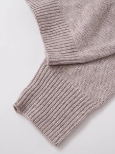 Detailed close-up of grey-pink knit fabric showing soft ribbed texture and premium wool finish