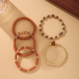 Detail of five-piece Bohemian stretch bracelets set with orange clay beads and gold accents
