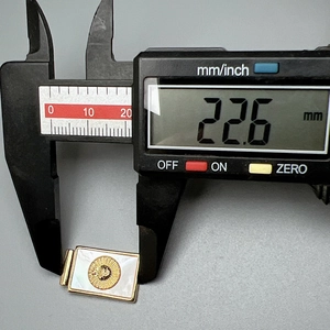 Calibro digitale che misura la larghezza di 22,6 mm del ciondolo dorato con madreperla