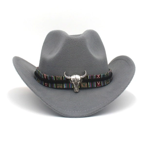Détail du chapeau de cowboy en feutre gris foncé avec bande ethnique et tête de taureau argentée