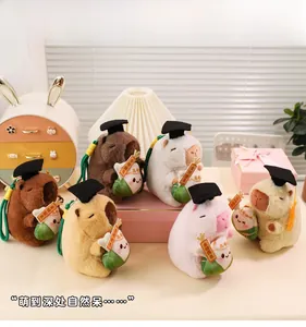Close-up of plush Capybara keychains wearing graduation caps with good luck charms