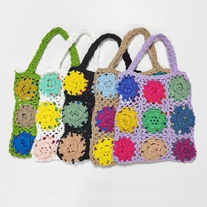 Close-up of five handmade crochet tote bags showing colorful floral patterns and textures