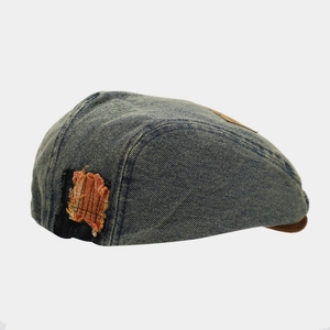 Vintage washed denim flat cap for women featuring distressed patch details in navy blue