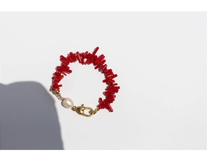 Close-up of red coral beads bracelet with white baroque pearl and golden heart clasp