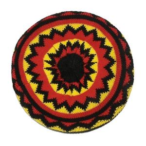 Detail of hand-knitted beanie featuring radial black, yellow, and red crochet patterns