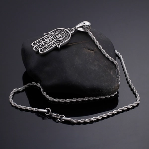 Retro silver Hamsa Hand devil eye pendant with rope chain on dark stone texture