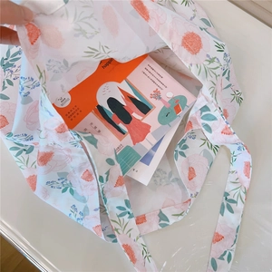 Detail showing high-capacity floral cotton tote bag holding books for daily use