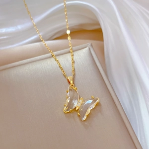 Collana con pendente a farfalla dorata con ali di cristallo su una scatola di seta