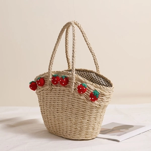 Handmade straw basket bag with red yarn strawberries and polka dot lining for beach vacations