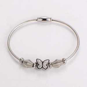 Close-up of silver braided wire bracelet with rhinestone butterfly charm and magnetic clasp