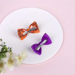Halloween bow hair clip set with Trick or Treat print for girls on white plate