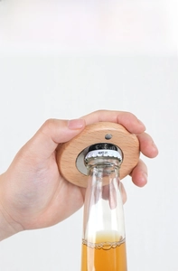 Close-up of a wooden magnetic bottle opener showing stainless steel opener teeth and wood texture