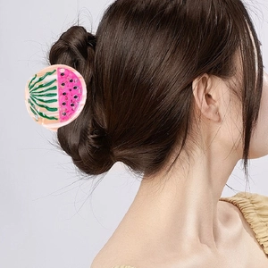 Watermelon slice hair claw clip in pink and green resin on a model's brown hair