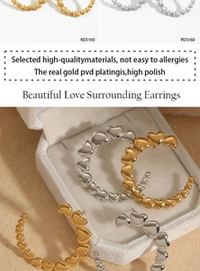 Detail of PVD gold plated C-shaped heart earrings on a white velvet jewelry box