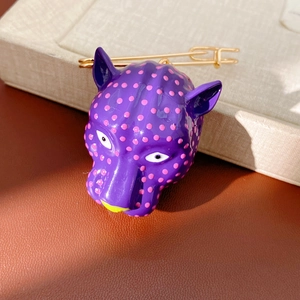 Vue détaillée d'une broche tête de panthère violette à pois roses
