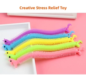 Detail showing five colorful unicorn stretch toys on a white tray with textured spikes