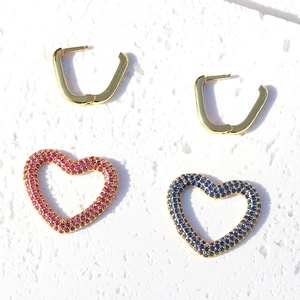 Dettaglio di orecchini a cuore placcati oro 18 carati con zirconi rosa e blu