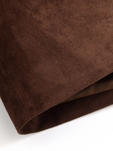 Macro detail showing the rich texture of dark brown suede fabric on a classic blazer