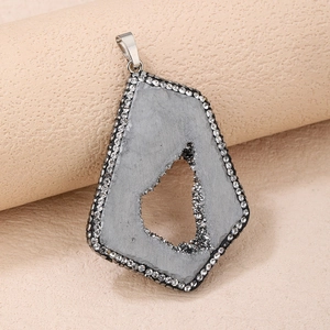 Macro detail of natural gray agate druzy pendant with sparkling rhinestone pavé edges