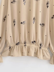 Détail de broderie florale à paillettes champagne avec taille élastique et volants