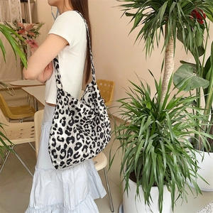 Fashionable leopard print canvas tote bag shown as a crossbody shopping bag on a model