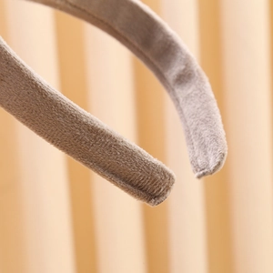 Macro shot of the soft light brown plush fabric texture and neat edge stitching on the headband