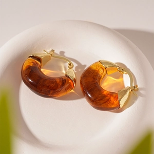 Detail view of amber resin hoop earrings with elegant gold-plated secure closures