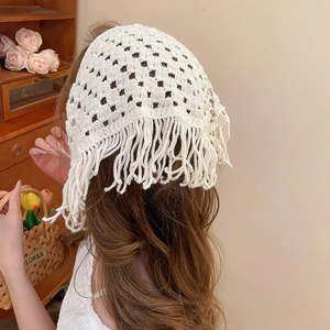 Detail of white crochet hollow triangle scarf with tassels for French vintage styling