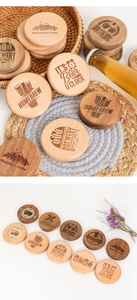 Detail of wooden magnetic beer bottle openers with various engraved brewery patterns