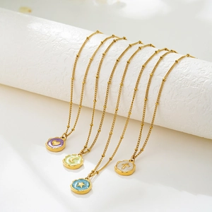 Detail of 18K gold-plated beaded necklaces with colorful enamel heart, moon, and star charms