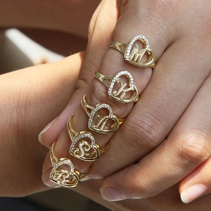 Gold heart initial ring with sparkling pavé crystals worn on a model hand