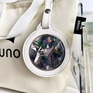 Detail van witte katvormige badgehouder met holografische anime-pin op een stoffen tas