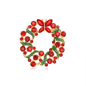 Detail of a gold Christmas boot brooch with red rhinestones and green enamel leaf detail