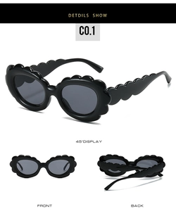 Detail view of oval sunglasses with unique wavy petal frame design and black finish