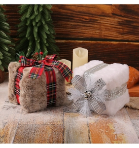 Detail of plush Christmas gift box ornaments in brown and white on a rustic wooden background