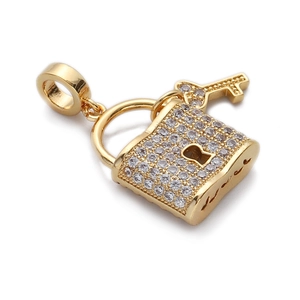 Détail d'un pendentif serrure et clé plaqué or serti de zircons sur fond blanc épuré