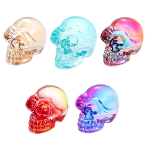 Five crystal skull ornaments in gradient translucent metallic colors on white background