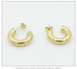 Detail view of bold C-shaped gold stainless steel hoop earrings with polished finish