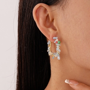Boucles d'oreilles créoles faites main avec pierres d'aigue-marine colorées sur un mannequin