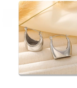 Macro detail of silver-tone stainless steel hoop earrings with polished mirror finish