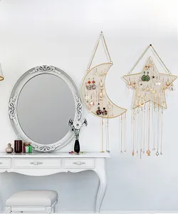 Detail of star and moon shaped gold wire mesh wall organizers with hooks for jewelry