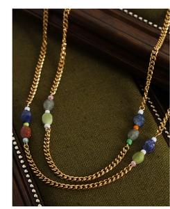 Detail of vintage gold-plated titanium flat chain with colorful natural stone beads