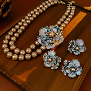 Macro shot of vintage floral earrings and pearl necklace with colorful gemstones