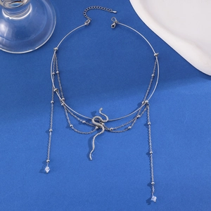Detail van zilveren slangencollier met franjekettingen en hangers van kristal