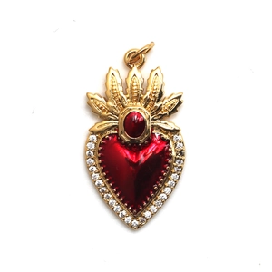 Macro shot of gold heart pendant with red enamel, crown detail, and tiny crystals