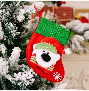 Close-up of a sequined Christmas stocking with a 3D polar bear on a snowy tree