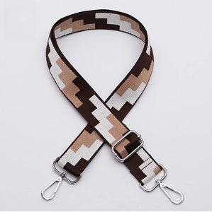 Close-up of geometric pattern woven bag strap with silver metal lobster clasps and slider
